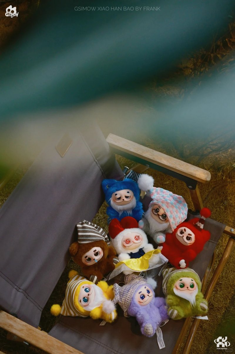 Nine GISMOW plush charms in knitted hats arranged together outdoors